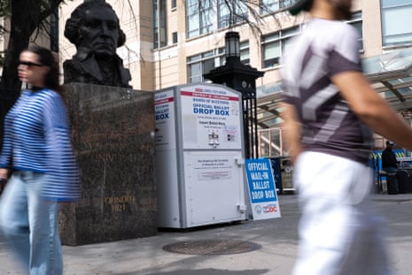 people walking past voting drop box