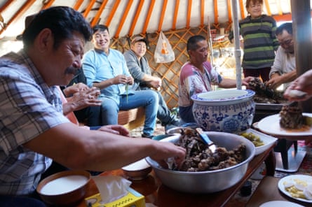Ariunbaatar Ganbaatar, centre in pale blue shirt, at a family gathering in their yurt.
