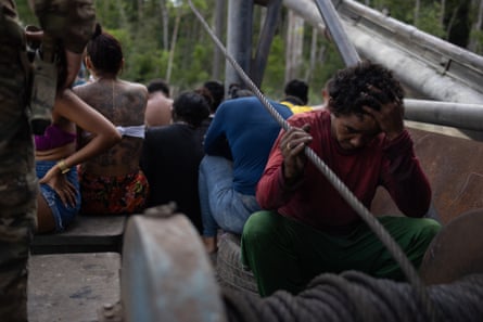 A man sits on a boat with one hand held to his forehead