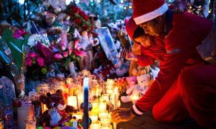 A mourner lights a candle for those who died at Sandy Hook Elementary School in December 2012.