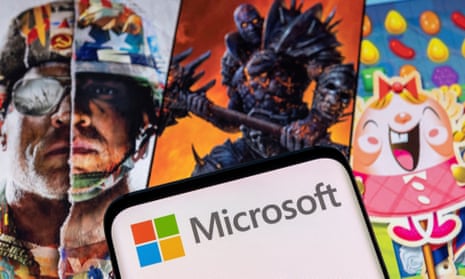 Microsoft logo on a smartphone placed on displayed Activision Blizzard's games characters