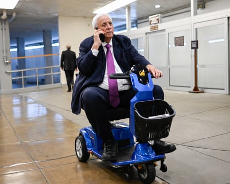 a man speaks on the phone while driving a motorized scooter