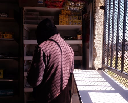 Abebe with his back to the camera in the corner shop