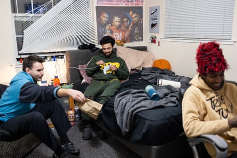 Three men in a bedroom hanging out