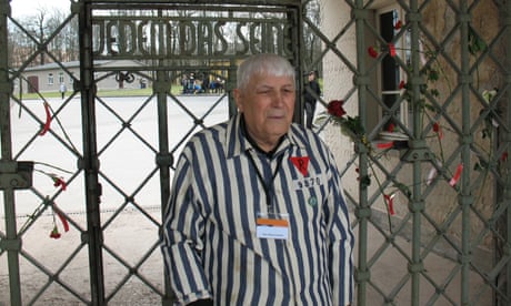 Boris Romanchenko wearing a blue and white striped shirt with his prisoner number in front of Buchenwald concentration camp during a memorial