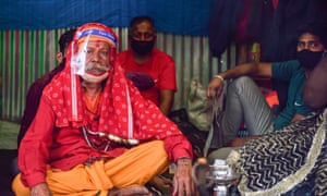 Hindu monk wearing a face shield seen at a transit camp for Gangasagar Mela at Babughat.