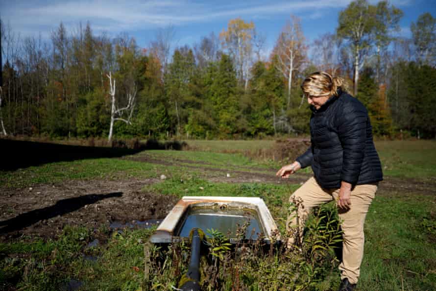 Bonnie Pauze examines the water flowing from her artesian well.