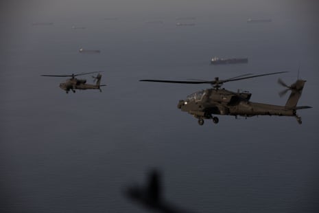 AH-64 Apaches fly above the strait of Hormuz during a patrol.