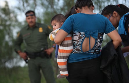 Families of Central American immigrants turn themselves in to US Border Patrol agents after crossing the Rio Grande river from Mexico to McAllen, Texas