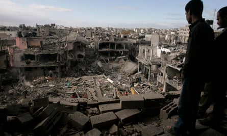 Palestinians look down on the destroyed house of a Hamas militant after an Israeli airstrike in the Gaza Strip, 2 January 2009