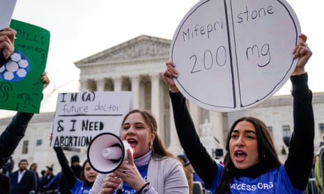 A large group of people stand at protest, holding up signs such as 'Mifepristone 200mg' and 'I'm a future doctor & I need abortion'