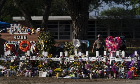 Flowers and candles are placed around crosses at a memorial outside Robb elementary school to honor the victims killed in this week's school shooting in Uvalde, Texas.
