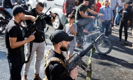 Men with guns in the funeral procession in Jenin