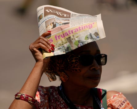 a woman holds a newspaper above her head
