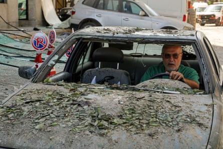 A man drives a battered-looking car that has no windows
