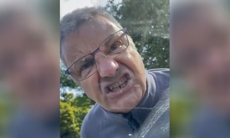 An angry white man with teeth bared snarling at the camera