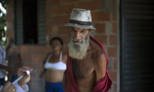 Manuel de Freitas removes his shirt to expose his arm as a health worker fills a syringe with a yellow fever vaccine in Casimiro de Abreu, Brazil, last year.