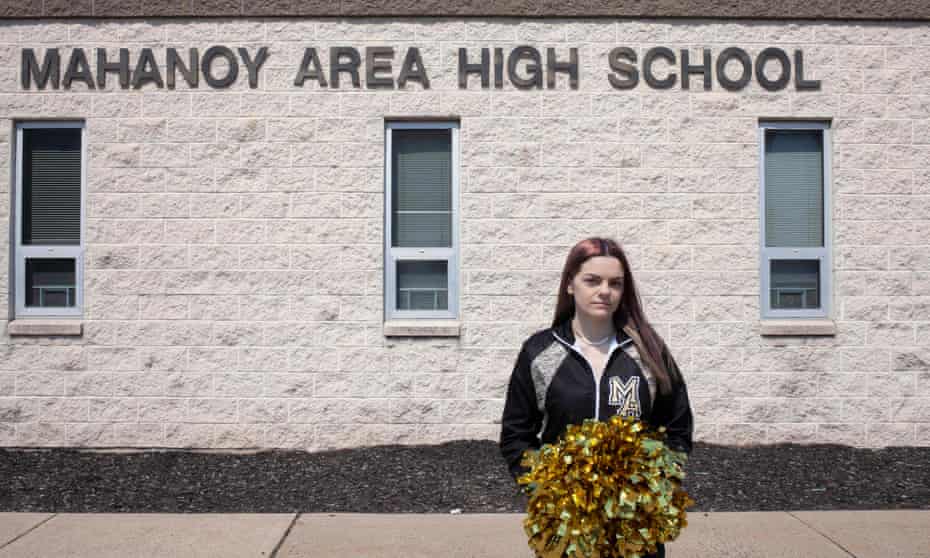 brandi levy with pom poms in front of school