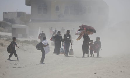 Palestinians, including women and children, living in the east of Khan Younis city move towards safe areas with whatever belongings they can take with them.