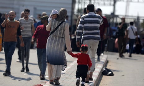 Palestinos, alguns com passaportes estrangeiros que esperam cruzar para o Egito e outros que aguardam ajuda, aguardam na passagem de Rafah, no sul da Faixa de Gaza.