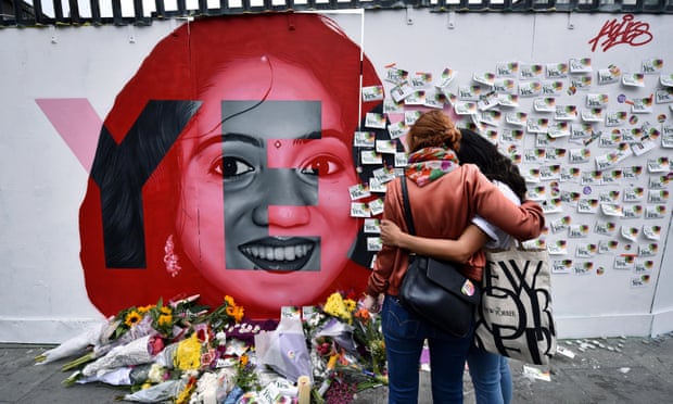 Two women console one another as they look at written notes left on the Savita Halappanavar mural in Dublin on Saturday