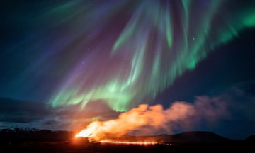 The volcano in Grindavik erupts beneath the northern lights.