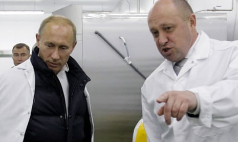 File photo taken on September 20, 2010, as businessman Yevgeny Prigozhin (right) shows Russian Prime Minister Vladimir Putin (left) his school lunch factory outside Saint Petersburg.