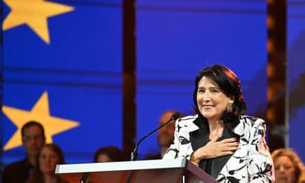 The Georgian president, Salome Zurabishvili, delivers a speech against a blue background with yellow stars