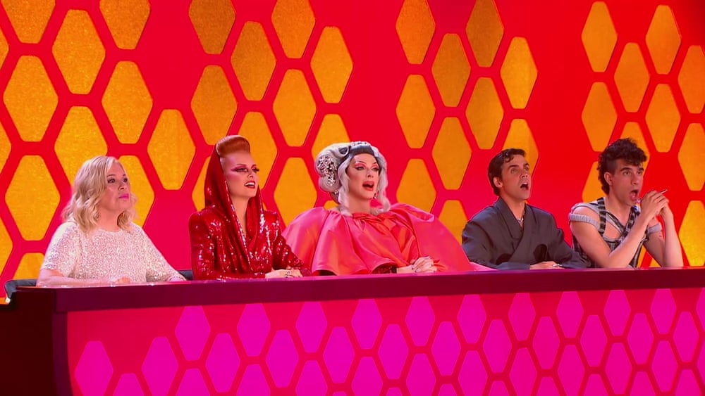 Drag Race España judges react with shocked expressions behind a desk on set