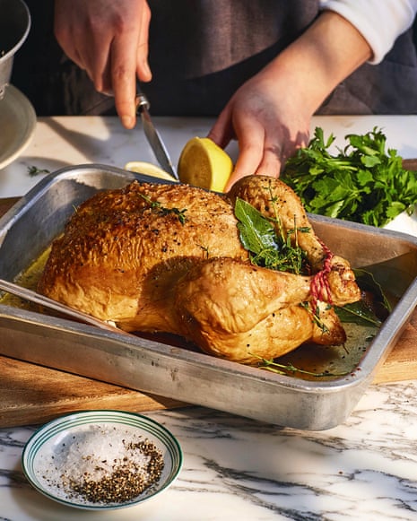 A person cuts into a roast chicken