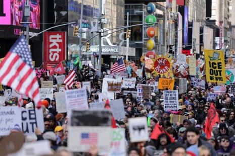 Demonstrators hold placards as they attend a No Kings protest.