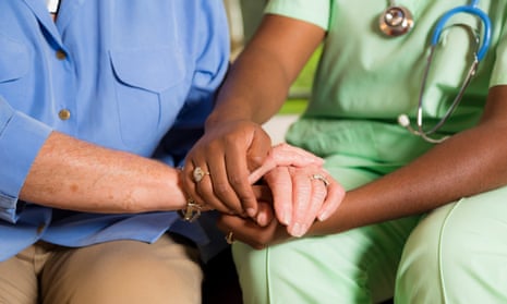 Nurse holds senior woman's hand