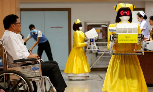Robots dressed in nurse outfits carrying medical documents work next to Thai patients at Mongkutwattana General Hospital in Bangkok.