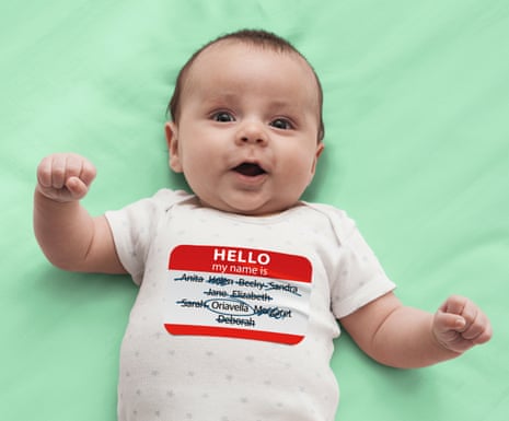 Baby wearing a vest with a label of lots of crossed out names apart from Oriavella