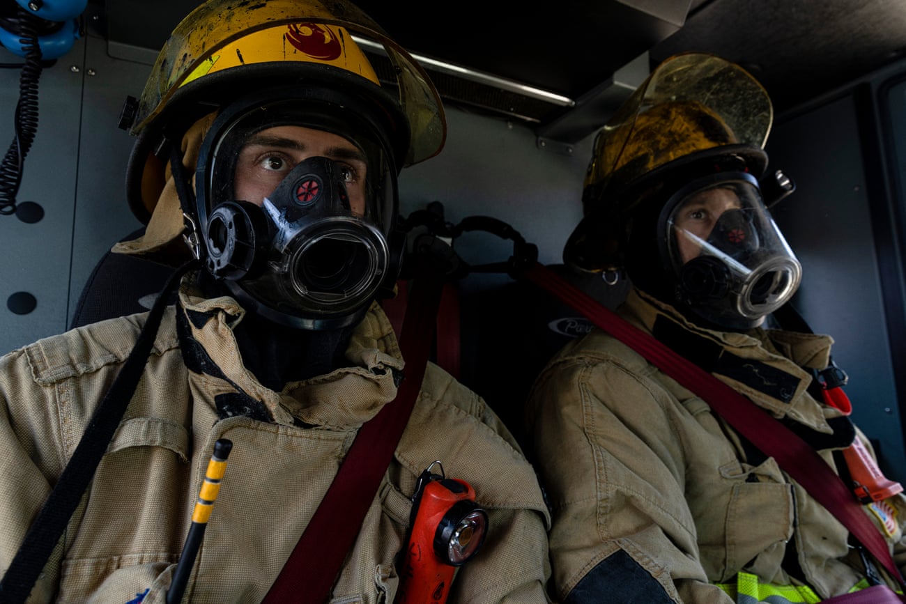 Closeup of firefighters in PPE inside a firetruck