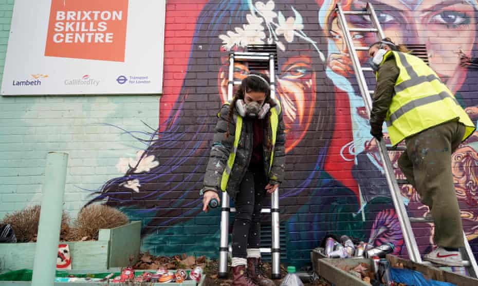Spanish artist Alba Bernal and British artist Vicky Lim, members of the Wom Collective, work on a mural in Brixton, London, to celebrate International Women’s Day.