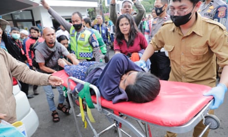 Rescuers transport an injured person in Cianjur, West Java