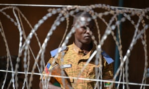 A member of Burkina Faso's security force behind barbed wire