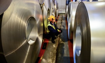 A worker inspecting rolls of steel