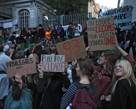 Protesters hold placards, one reading “Public private solidarity”, during a demonstration in front of the private Charles Peguy high school in Paris.