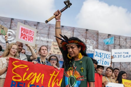 Woman in traditional headdress leads a demonstration