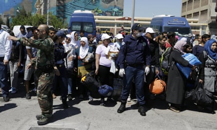 Athens coastguards give directions to refugees being transported out of the port of Piraeus.