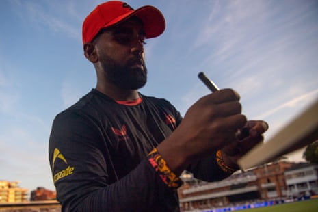 Rehan Ahmed in Birmingham Phoenix kit signs an autograph for a fan