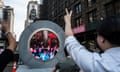 People in New York make peace sign with hands as they look at the portal