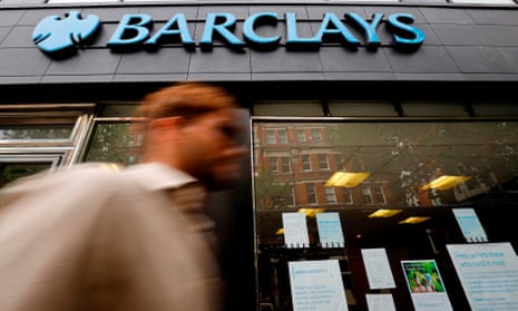 Pedestrian walks past a Barclays branch