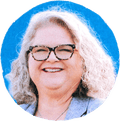 woman in glasses smiling against blue background