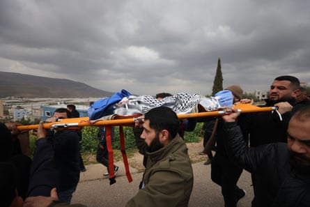 People carry a covered body on a stretcher