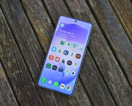 A photo of a Samsung Galaxy S26 Ultra laying on a wet table showing the home screen of app icons and Now Brief widget.