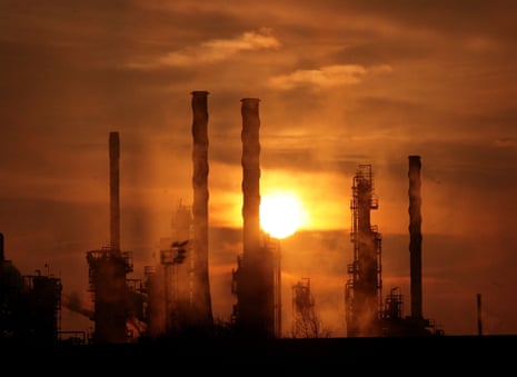 Towers of an oil refinery in North Lincolnshire against the backdrop of a setting sun