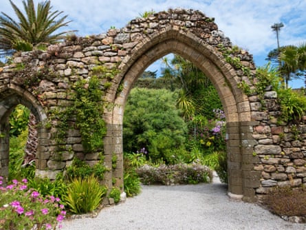 View of a stone arch and plants at Tresco Abbey Gardens, Tresco, Isles of Scilly, Cornwall, England, UK.